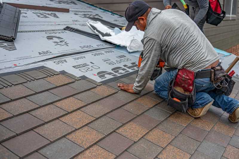 pexels-photo-37677394-37677394 Skilled roofer installing asphalt shingles, ensuring quality home renovation.